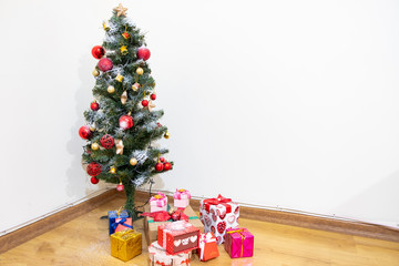 Beautiful christmas tree with  present boxes in the room.