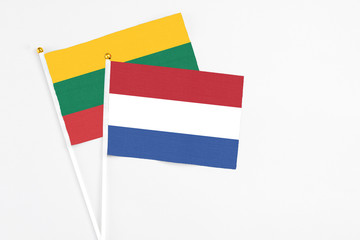 Netherlands and Lithuania stick flags on white background. High quality fabric, miniature national flag. Peaceful global concept.White floor for copy space.