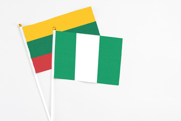 Nigeria and Lithuania stick flags on white background. High quality fabric, miniature national flag. Peaceful global concept.White floor for copy space.
