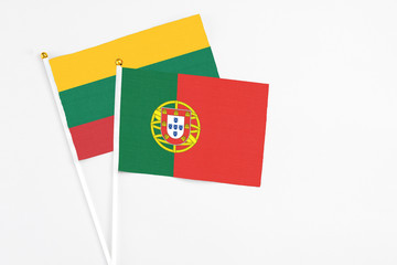 Portugal and Lithuania stick flags on white background. High quality fabric, miniature national flag. Peaceful global concept.White floor for copy space.