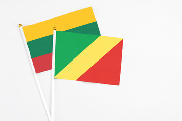 Fototapeta premium Republic Of The Congo and Lithuania stick flags on white background. High quality fabric, miniature national flag. Peaceful global concept.White floor for copy space.