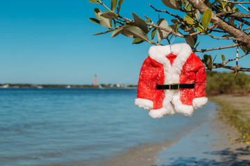 Christmas in Florida concept. Santa suit hanging on a Florida beach in New Smyrna Beach.