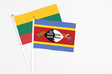 Swaziland and Lithuania stick flags on white background. High quality fabric, miniature national flag. Peaceful global concept.White floor for copy space.