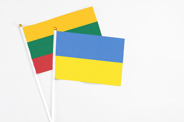 Ukraine and Lithuania stick flags on white background. High quality fabric, miniature national flag. Peaceful global concept.White floor for copy space.