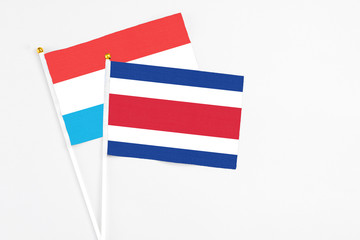 Costa Rica and Luxembourg stick flags on white background. High quality fabric, miniature national flag. Peaceful global concept.White floor for copy space.