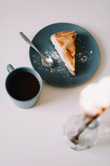 Piece of apple pie on plate with cup of coffee on white table. Breakfast with coffee and cake in cafe. food photography. 