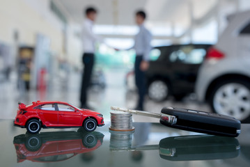 Car purchase agreement New car keys and money in the foreground. Blur background for two business man. Hand in hand