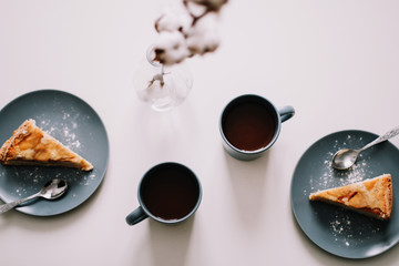 Piece of apple pie on plate with cup of coffee on white table. Breakfast with coffee and cake in cafe. food photography. 