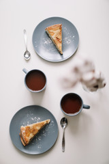 Piece of apple pie on plate with cup of coffee on white table. Breakfast with coffee and cake in cafe. food photography. 