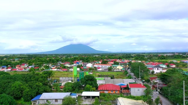4k aerial shot of town with mountain arayat in the background