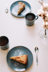 Piece of apple pie on plate with cup of coffee on white table. Breakfast with coffee and cake in cafe. food photography. 