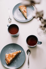 Piece of apple pie on plate with cup of coffee on white table. Breakfast with coffee and cake in cafe. food photography. 