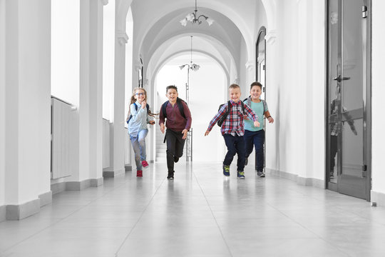 Pupils Playing Together And Running On School Corridor.