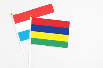 Mauritius and Luxembourg stick flags on white background. High quality fabric, miniature national flag. Peaceful global concept.White floor for copy space.
