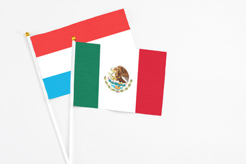 Mexico and Luxembourg stick flags on white background. High quality fabric, miniature national flag. Peaceful global concept.White floor for copy space.