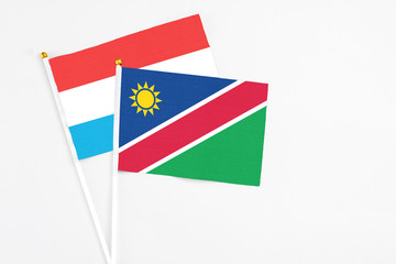 Namibia and Luxembourg stick flags on white background. High quality fabric, miniature national flag. Peaceful global concept.White floor for copy space.