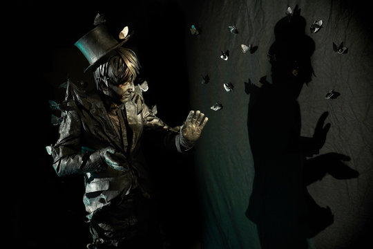 Portrait of skillful mime showing some figure by his shadow