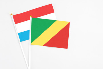 Republic Of The Congo and Luxembourg stick flags on white background. High quality fabric, miniature national flag. Peaceful global concept.White floor for copy space.