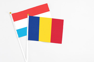 Romania and Luxembourg stick flags on white background. High quality fabric, miniature national flag. Peaceful global concept.White floor for copy space.