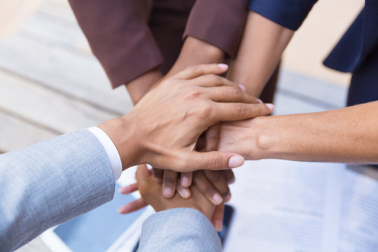 Business team putting their hands together, expressing unity, support, friendship. Closeup of people stacking hands. Teamwork and success concept