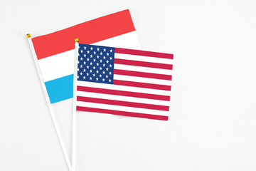 United States and Luxembourg stick flags on white background. High quality fabric, miniature national flag. Peaceful global concept.White floor for copy space.