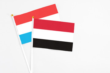 Yemen and Luxembourg stick flags on white background. High quality fabric, miniature national flag. Peaceful global concept.White floor for copy space.