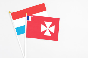 Wallis And Futuna and Luxembourg stick flags on white background. High quality fabric, miniature national flag. Peaceful global concept.White floor for copy space.