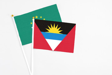 Antigua and Barbuda and Macao stick flags on white background. High quality fabric, miniature national flag. Peaceful global concept.White floor for copy space.