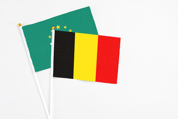 Belgium and Macao stick flags on white background. High quality fabric, miniature national flag. Peaceful global concept.White floor for copy space.