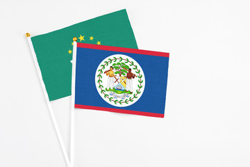 Belize and Macao stick flags on white background. High quality fabric, miniature national flag. Peaceful global concept.White floor for copy space.