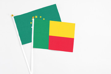 Benin and Macao stick flags on white background. High quality fabric, miniature national flag. Peaceful global concept.White floor for copy space.