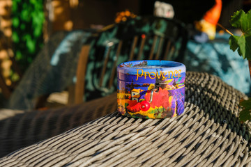 Cute music box with Provence landscape  on wicker surface in bright sun. Bright small hurdy-gurdy....
