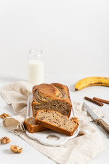 Butter-free, sugar-free banana bread with oat flour and honey. Sliced banana bread on white concrete background. Side view. Healthy nutrition recipe. Dieting. Selective focus