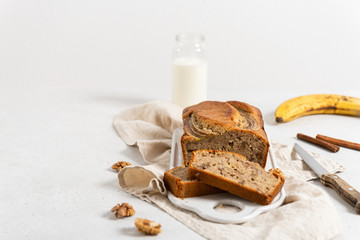 Homemade delicious banana cake with walnuts and cinnamon on white concrete background. Side view, close up. Bakery, recipe concept. Close up. Selective focus