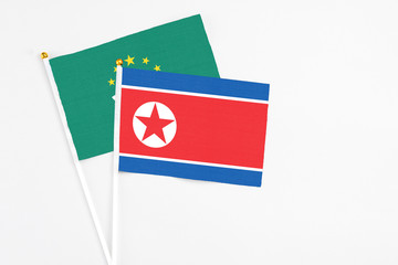 North Korea and Macao stick flags on white background. High quality fabric, miniature national flag. Peaceful global concept.White floor for copy space.