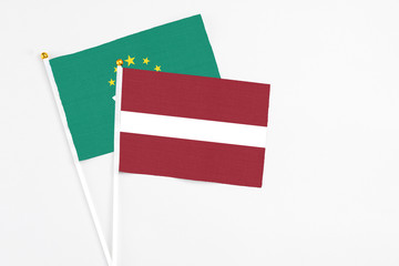 Latvia and Macao stick flags on white background. High quality fabric, miniature national flag. Peaceful global concept.White floor for copy space.