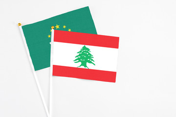 Lebanon and Macao stick flags on white background. High quality fabric, miniature national flag. Peaceful global concept.White floor for copy space.