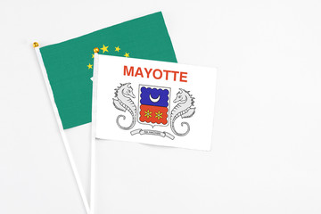 Mayotte and Macao stick flags on white background. High quality fabric, miniature national flag. Peaceful global concept.White floor for copy space.