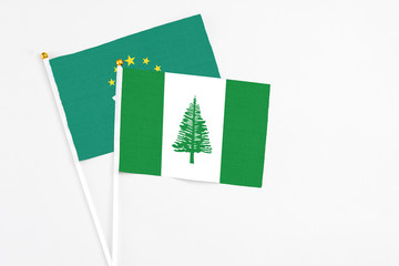 Norfolk Island and Macao stick flags on white background. High quality fabric, miniature national flag. Peaceful global concept.White floor for copy space.