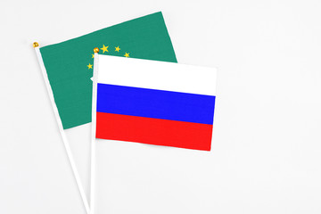 Russia and Macao stick flags on white background. High quality fabric, miniature national flag. Peaceful global concept.White floor for copy space.