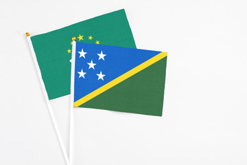 Solomon Islands and Macao stick flags on white background. High quality fabric, miniature national...
