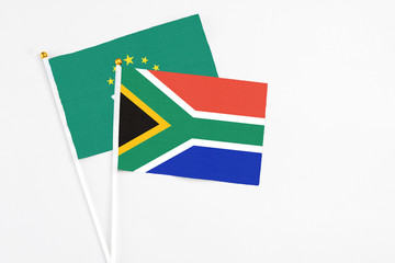 South Africa and Macao stick flags on white background. High quality fabric, miniature national flag. Peaceful global concept.White floor for copy space.