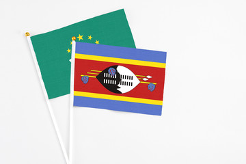 Swaziland and Macao stick flags on white background. High quality fabric, miniature national flag. Peaceful global concept.White floor for copy space.
