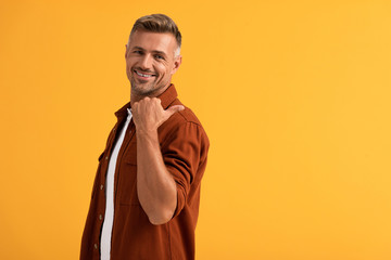 happy man showing thumb up isolated on orange