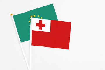 Tonga and Macao stick flags on white background. High quality fabric, miniature national flag. Peaceful global concept.White floor for copy space.