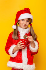 Child wearing Santa costume eating milk and cookies