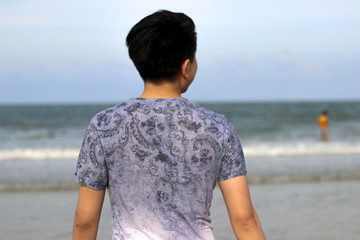 Close up of Men's back of Young men in front of the sea and beach
