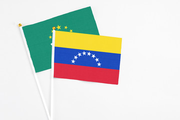 Venezuela and Macao stick flags on white background. High quality fabric, miniature national flag. Peaceful global concept.White floor for copy space.