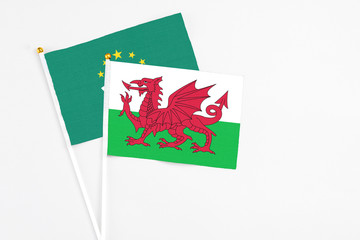 Wales and Macao stick flags on white background. High quality fabric, miniature national flag. Peaceful global concept.White floor for copy space.