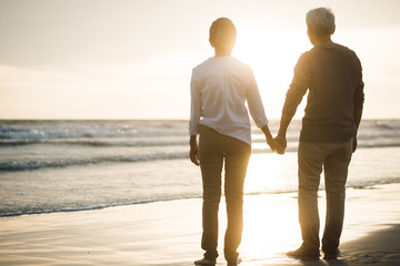 Romantic Silhouette hugging couple holding hand on the beach. sunset in background...